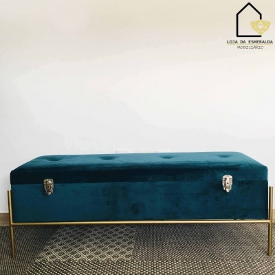 Banco baú de veludo azul escuro com estrutura metálica dourada e fechos prateados