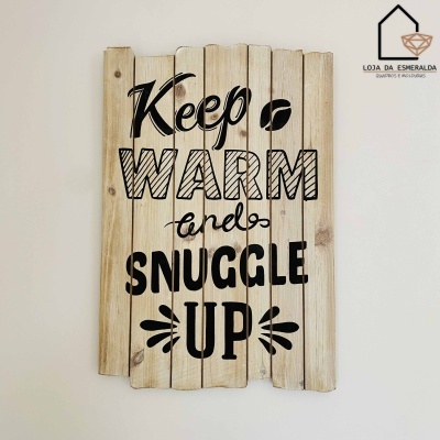 Placa decorativa de madeira com texto em preto pendurada na parede