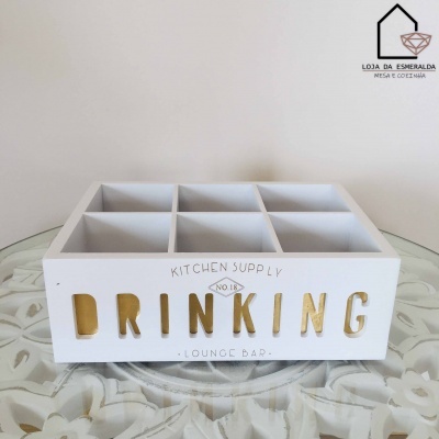 Caixa organizadora branca em madeira com texto decorativo e divisórias sobre mesa de vidro