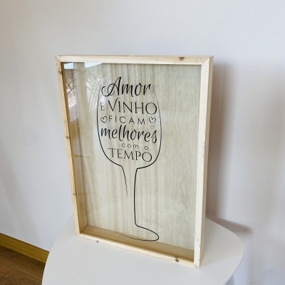 Quadro decorativo com moldura de madeira e vidro, desenho de copo de vinho e texto em português