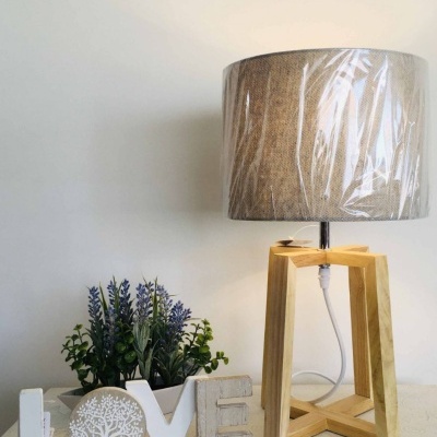 Abajur de madeira e tecido com decoração LOVE e plantas artificiais numa mesa branca