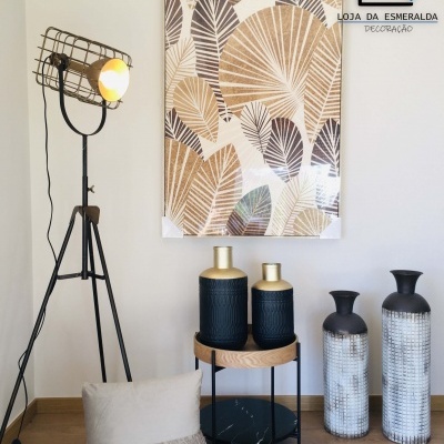 Decoração interior com lâmpada de tripé, almofada, jarras decorativas e quadro abstrato