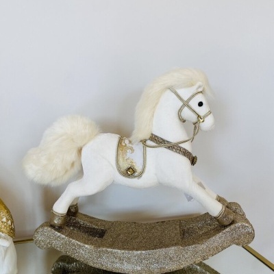 Cavalo de baloiço decorativo branco com detalhes dourados numa base brilhante