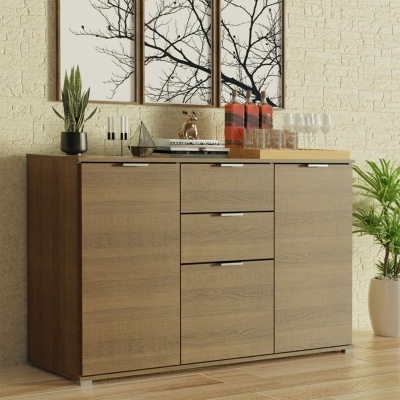 Aparador de madeira clara com decoração e quadros de galhos secos ao fundo