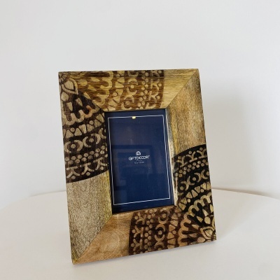 Moldura de madeira decorativa com padrões castanhos e inserção azul com texto