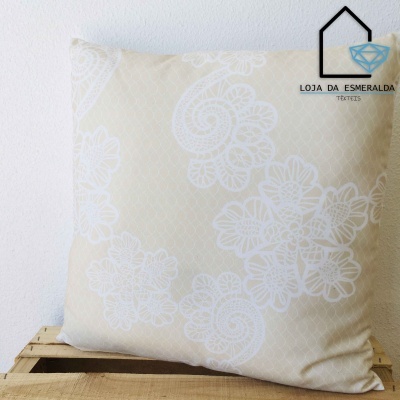 Almofada bege com padrão floral branco numa caixa de madeira