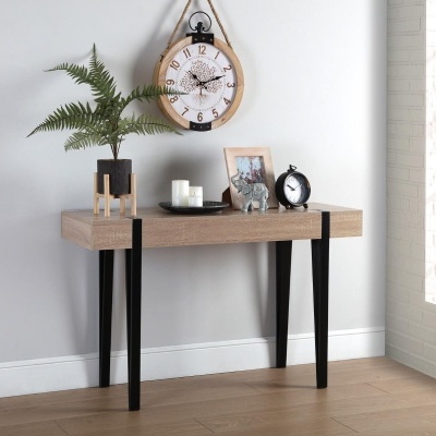 Mesa com decoração incluindo vaso, velas, moldura, elefante e relógio