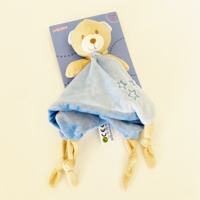 Pelúcia de ursinho com manta azul e cartão de embalagem azul