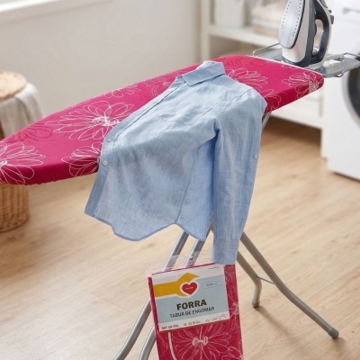 Tábua de engomar com capa vermelha, ferro e camisa azul clara