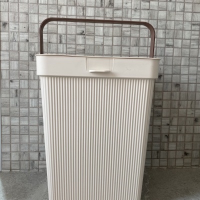 Cesto de plástico creme com pega castanha e textura em linhas verticais