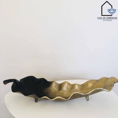 Fruteira bandeja em forma de folha preto e dourado sobre mesa branca