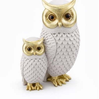 Estatuetas de coruja branca com detalhes dourados em fundo branco