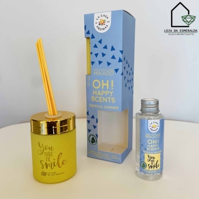 Conjunto de aromatizadores Mikado com frasco amarelo, embalagem azul e frasco transparente visível