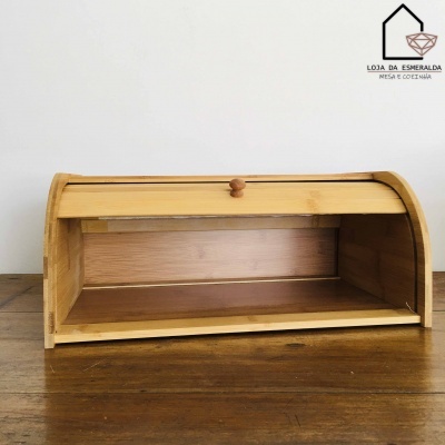 Caixa de pão de madeira clara com tampa de enrolar em mesa de madeira escura