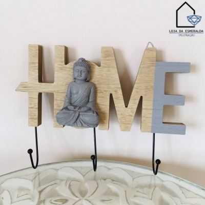 Suporte de parede decorativo com palavras 'HOME' em madeira e estátua de Buda cinzenta, com ganchos pretos.
