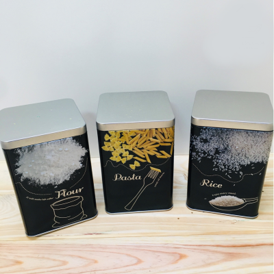 Três latas metálicas para farinha, massa e arroz com design preto e tampa prateada