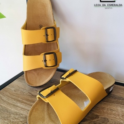 Sandálias amarelas com duas tiras e fivelas, solas bege e pretas