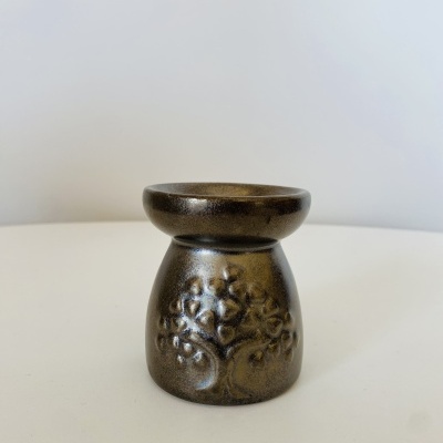 Velaira ou suporte decorativo em cerâmica castanha com relevo de árvore.