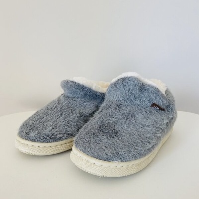 Chinelos cinzentos felpudos com interior branco sobre superfície branca