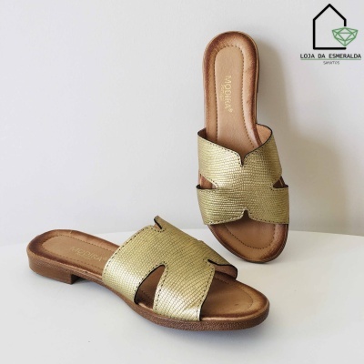 Sandálias douradas com textura tipo pele de cobra e sola castanha