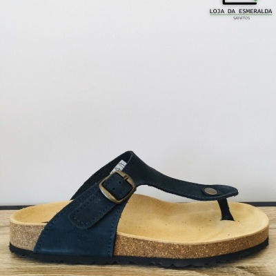 Sandália chinelo preta com sola de cortiça e logo da loja ao fundo