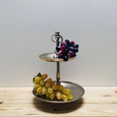 Prato de metal de dois andares com uvas pretas e verdes