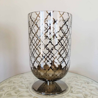 Vaso decorativo em vidro com padrão dourado sobre mesa branca com relevo