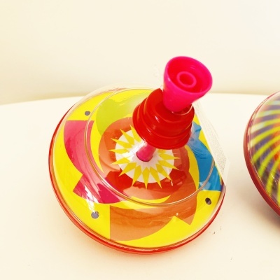 Pião de plástico colorido com padrão cônico e base transparente