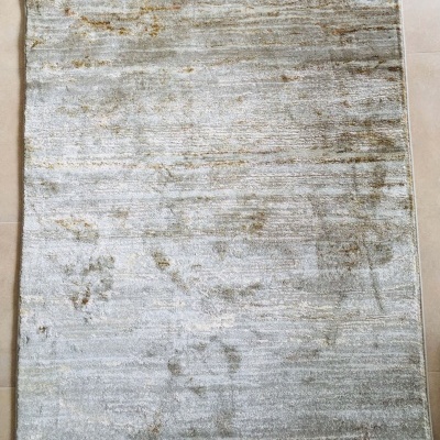 Tapete rectangular cinza claro e acastanhado sobre azulejos bege