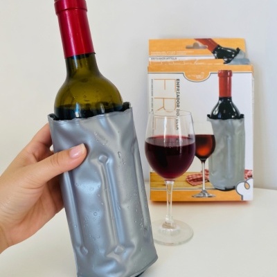 Garrafa de vinho no esfriador cinza com caixa e copo de vinho no fundo