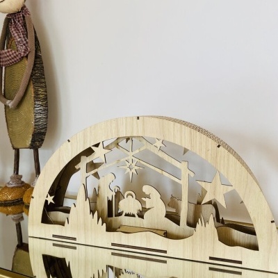 Decoração natalícia em madeira com presépio recortado e boneco decorativo ao lado