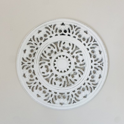 Painel decorativo circular branco com padrão recortado sobre parede cinza claro