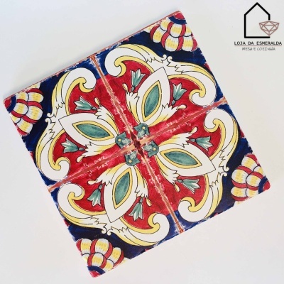 Conjunto de quatro azulejos decorativos em cerâmica coloridos com padrão floral e geométrico