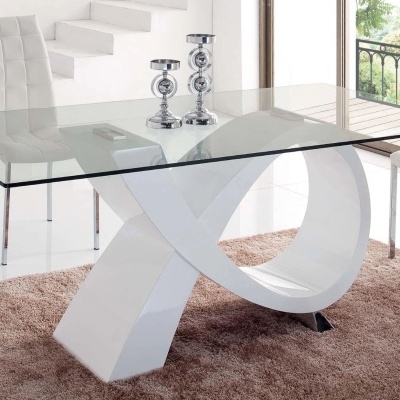 Mesa de vidro com base branca em forma de X e cadeiras brancas