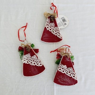 Ornamentos de Natal vermelhos com renda e pinhas sobre tecido branco