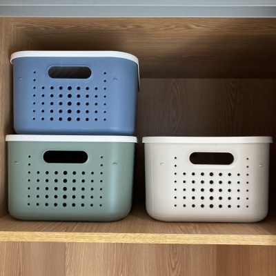 cestos de plástico azul, verde e branco em estante de madeira