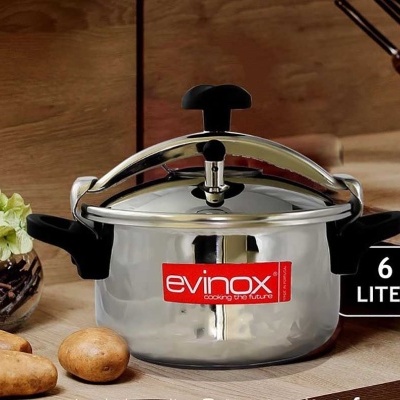 Panela de pressão inox 6 litros sobre bancada de cozinha com batatas e planta