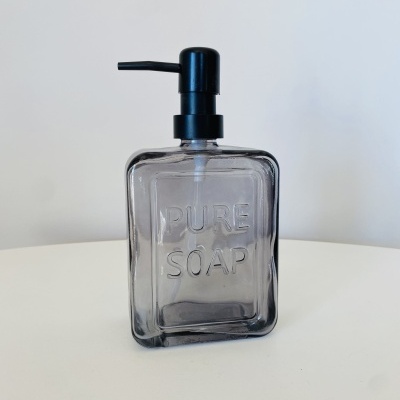 Frasco dispensador quadrado transparente com tampa preta e texto PURE SOAP em relevo.
