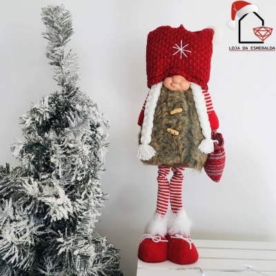 Boneco de Natal decorativo ao lado de árvore de Natal com neve falsa