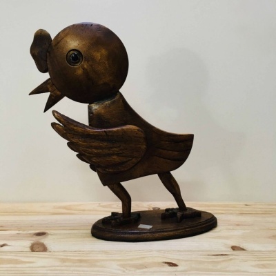 Estatueta em madeira de pássaro sobre base oval