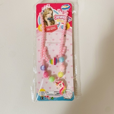 Colar infantil rosa com conta unicórnio e conta arco-íris em embalagem rosa com corações