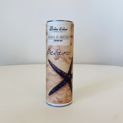 Frasco cilíndrico de bruma de ambiente com design de estrela-do-mar e texto em espanhol.