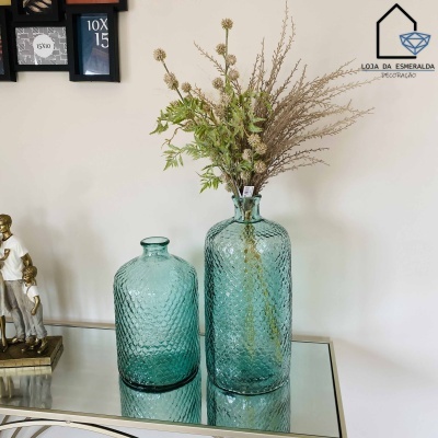 Dois vasos azuis texturizados em vidro com ramos secos numa mesa espelhada