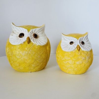 Duas corujas decorativas amarelas em cerâmica com detalhes brancos no rosto e olhos castanhos