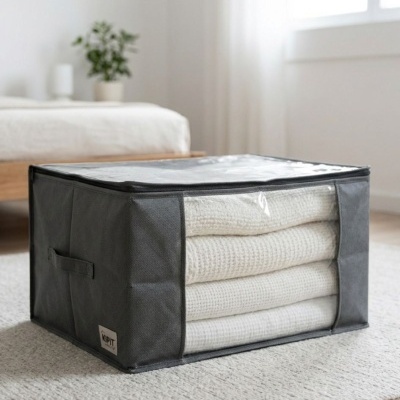 Organizador de armazenamento cinzento escuro com cobertores brancos dentro em quarto