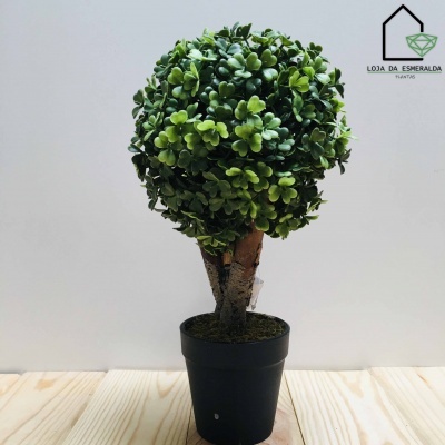 Planta artificial verde em vaso preto com tronco castanho e logótipo Loja da Esmeralda