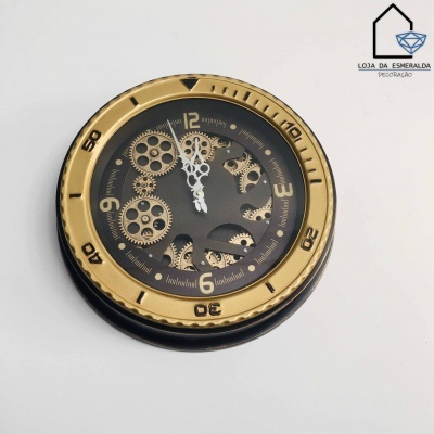 Relógio de parede preto e dourado com engrenagens visíveis e texto da loja no canto