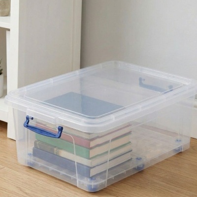 Caixa organizadora transparente com livros no chão de madeira