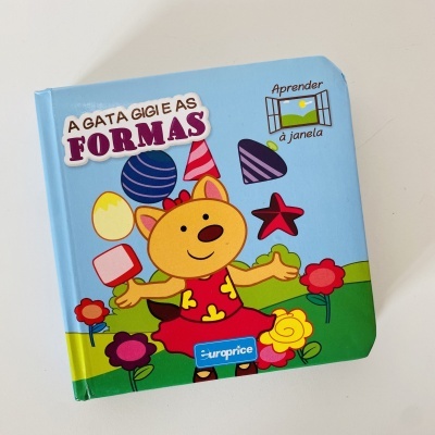 Livro infantil A GATA GIGI E AS FORMAS com capa azul e ilustrações coloridas