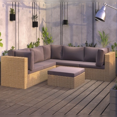 Sofá de canto exterior em vime natural com almofadas cinza e pufe, em área com chão de madeira e plantas
